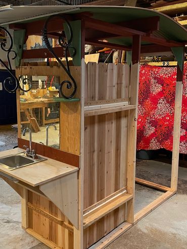 Wooden playhouse frame with a small sink and faucet setup.