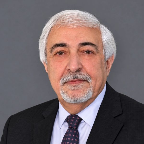 Professional portrait of an older man in a suit.
