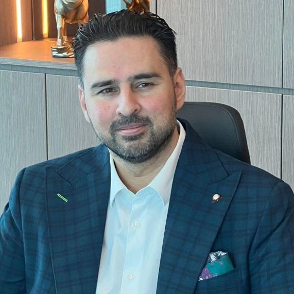 Man in a blue checkered suit smiling.
