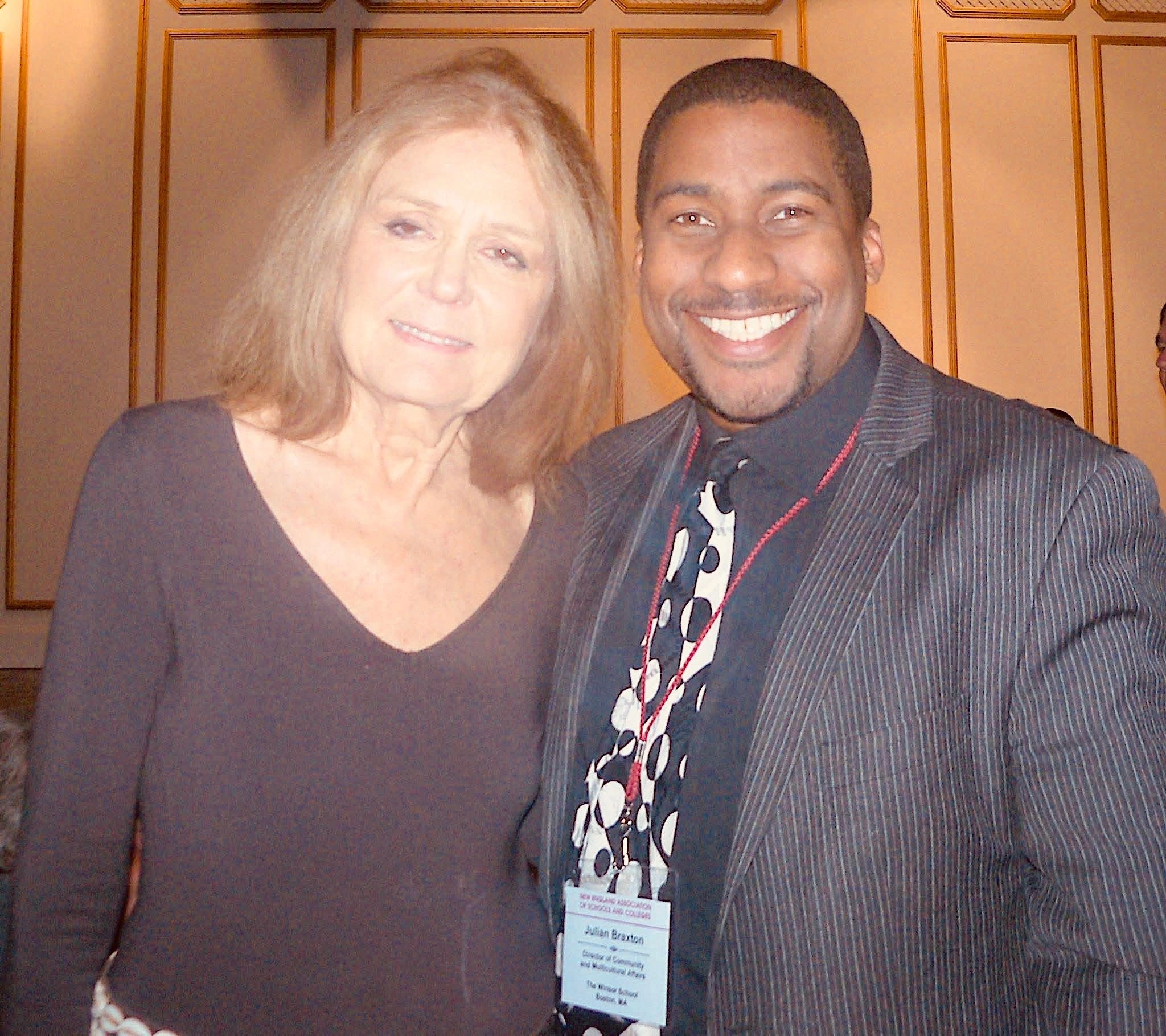 Two people smiling at the camera indoors.