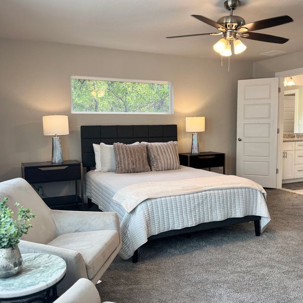 Master suite with queen bed, desk and chair and spacious sitting area