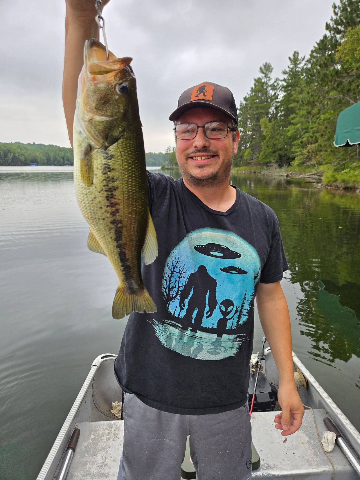 Man proudly holding a large fish on a boat.