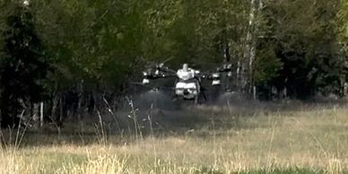 A DJI AGRAS Spray Drone out in a pasture spraying for weeds.
