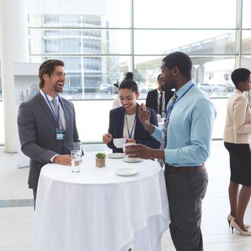 A group of conference attendees laughing and enjoying snacks in between keynote sessions.