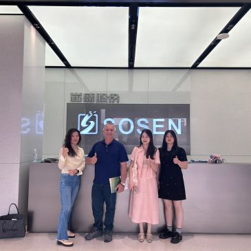 Four people posing with thumbs up at a reception desk.