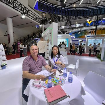 Two people sitting at a table in an exhibition hall.