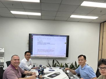 Four men having a meeting in a conference room.