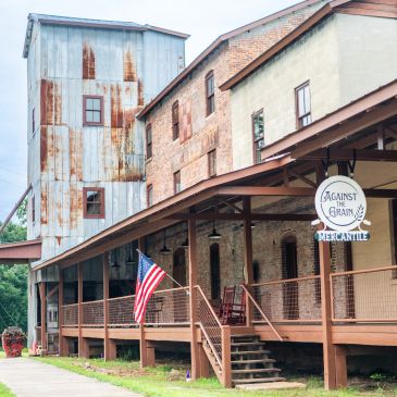 Rustic mercantile building with an American flag outside.