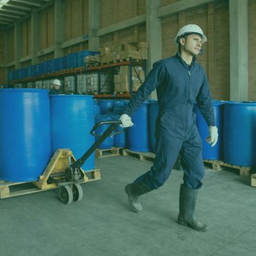 Man in work gear operating forklift containing recycled barrels