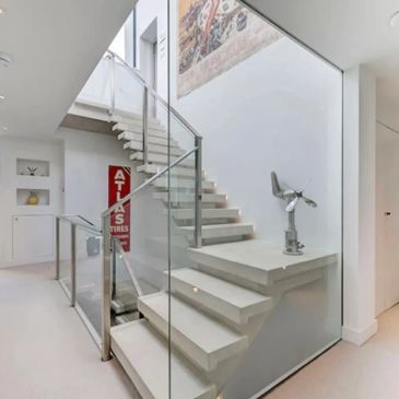 Modern staircase with glass railing and minimalist design.