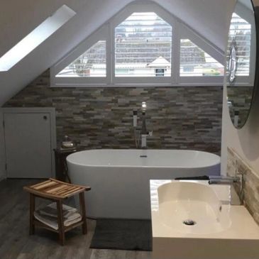 Modern bathroom with bathtub and triangular window.