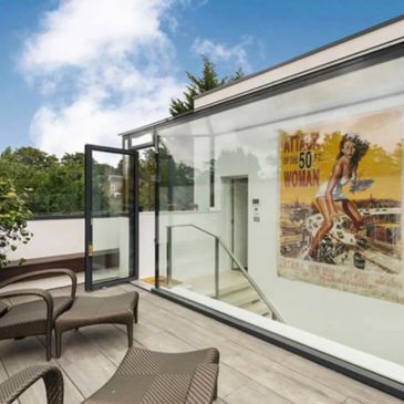 Modern balcony with glass railing and vintage poster.