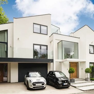 Modern house with two cars parked outside.