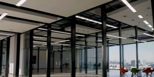 Modern office interior with glass partitions and city view.