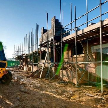 Building under construction with scaffolding on a sunny day.