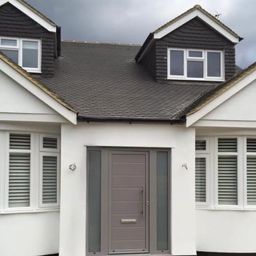 Modern house entrance with gray door and white walls.