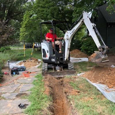 plumber on tractor installing new water line