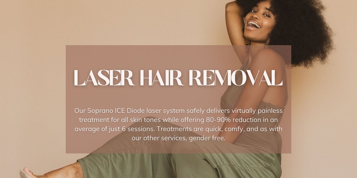 A Black woman in a green jumper smiles at the camera, her hair is a beautiful natural afro.