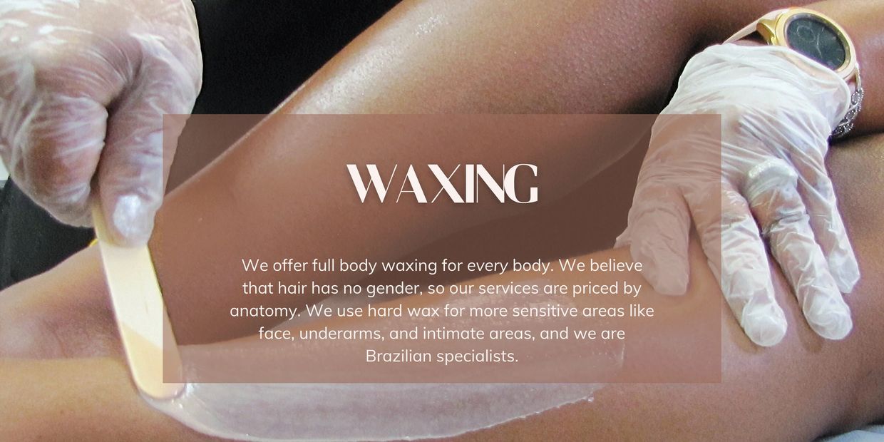 Gloved hands spreading wax onto someone's legs.