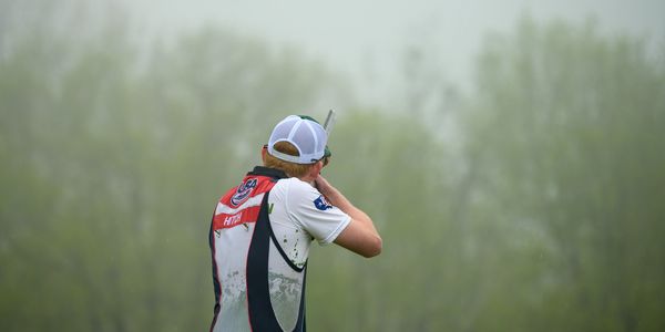 Athlete aiming in shooting sport outside.