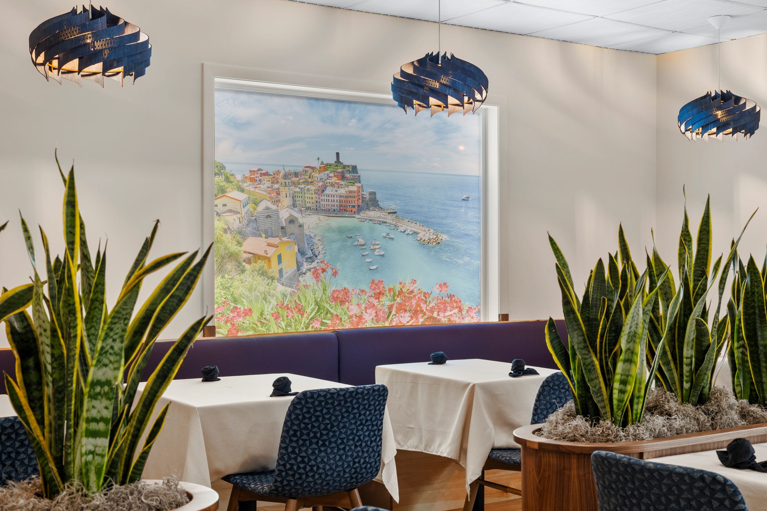 Modern dining room with sea view of Vernazza, Cinque Terre, Italy and stylish lighting.