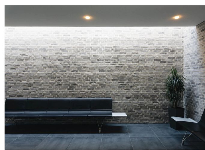 Three adults focused on drawing portraits on easels in an art class.