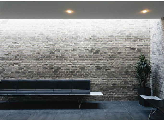 Three adults focused on drawing portraits on easels in an art class.