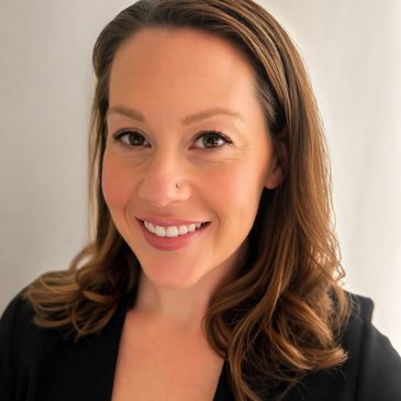 Smiling woman with light makeup and loose brown hair.