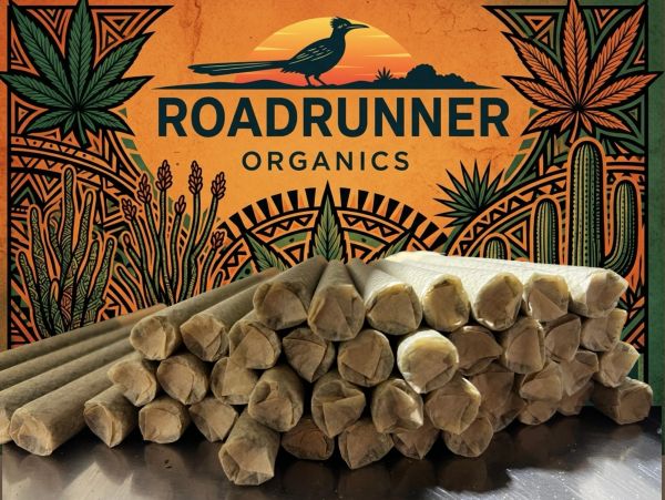 Stack of rolled organic products in front of a vibrant desert-themed sign.