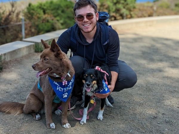 Bryce poses with in front of the Golden Gate Bridge with his two dogs, Athena and Aurora. 