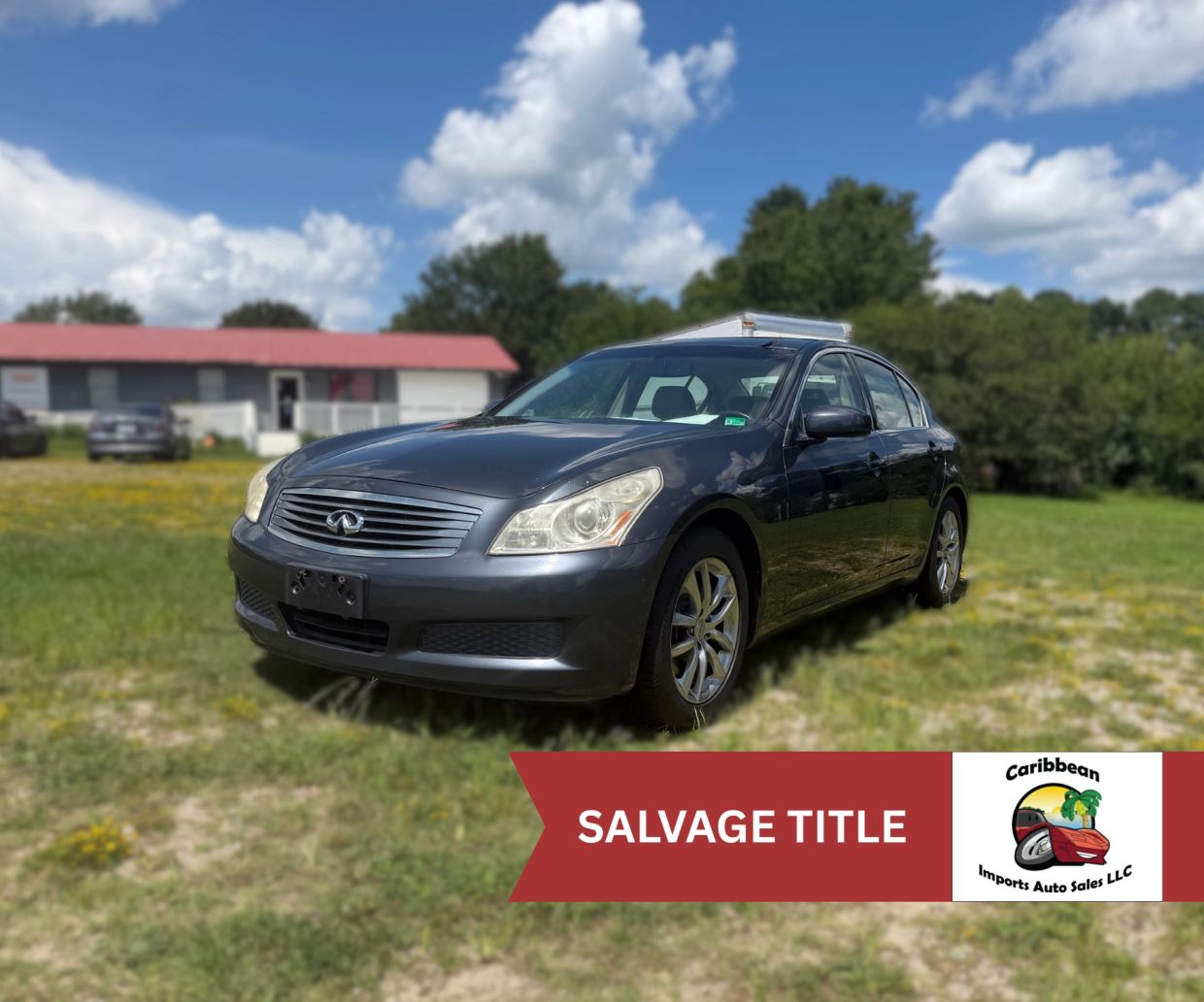 Black Infiniti sedan with salvage title parked on grass.