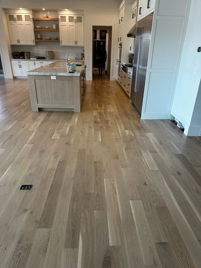 Modern kitchen with wooden floors and a central island.