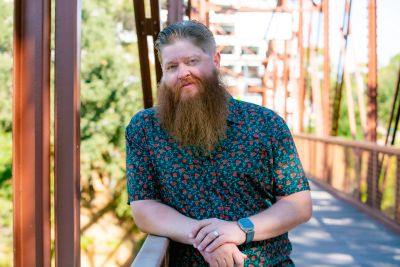 Man with a long beard on a bridge.
