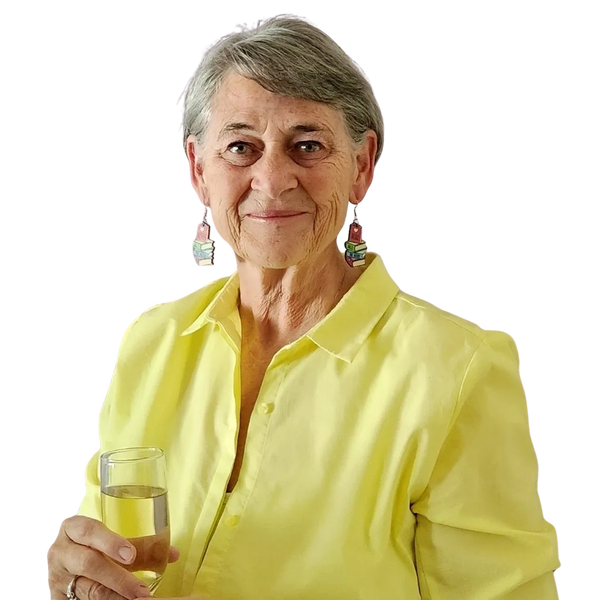 Smiling elderly woman in a bright yellow shirt holding a glass of water.