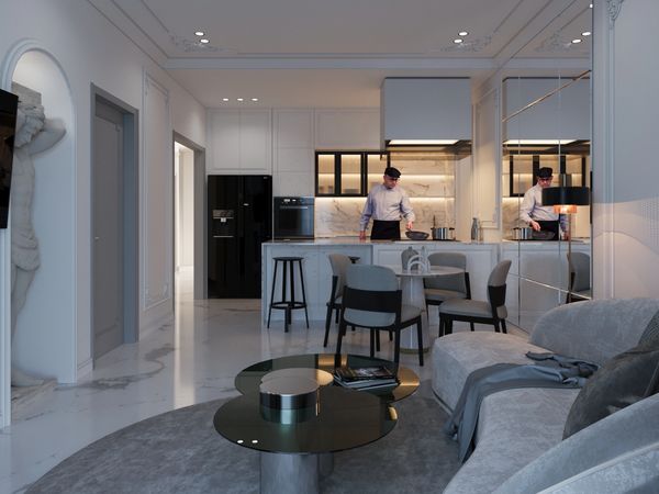 Modern kitchen and living room with marble floors and a person cooking.
