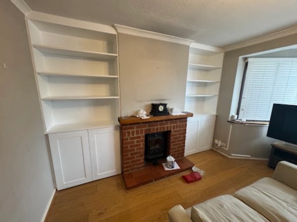 Cozy living room with a brick fireplace and white built-in shelves.
