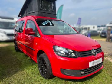 red vw caddy camper in field