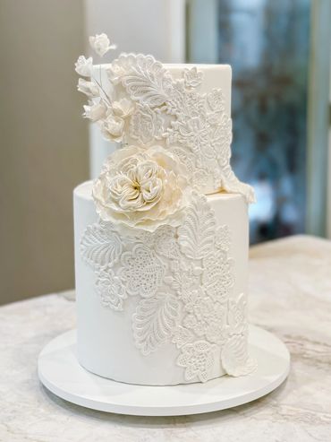 buttercream cake with fondant lace flower appliqués and sugar paste flowers