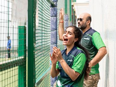 Two enthusiastic spectators cheer during an outdoor sports event.