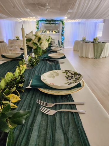 Elegant table setting with floral plates and greenery at a decorated event.