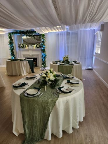 Elegant wedding reception setup with white and green decor.