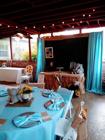 Elegant turquoise-themed party setup with sunflower decorations and plush elephants.