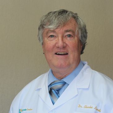 Smiling male doctor in white coat and striped tie.