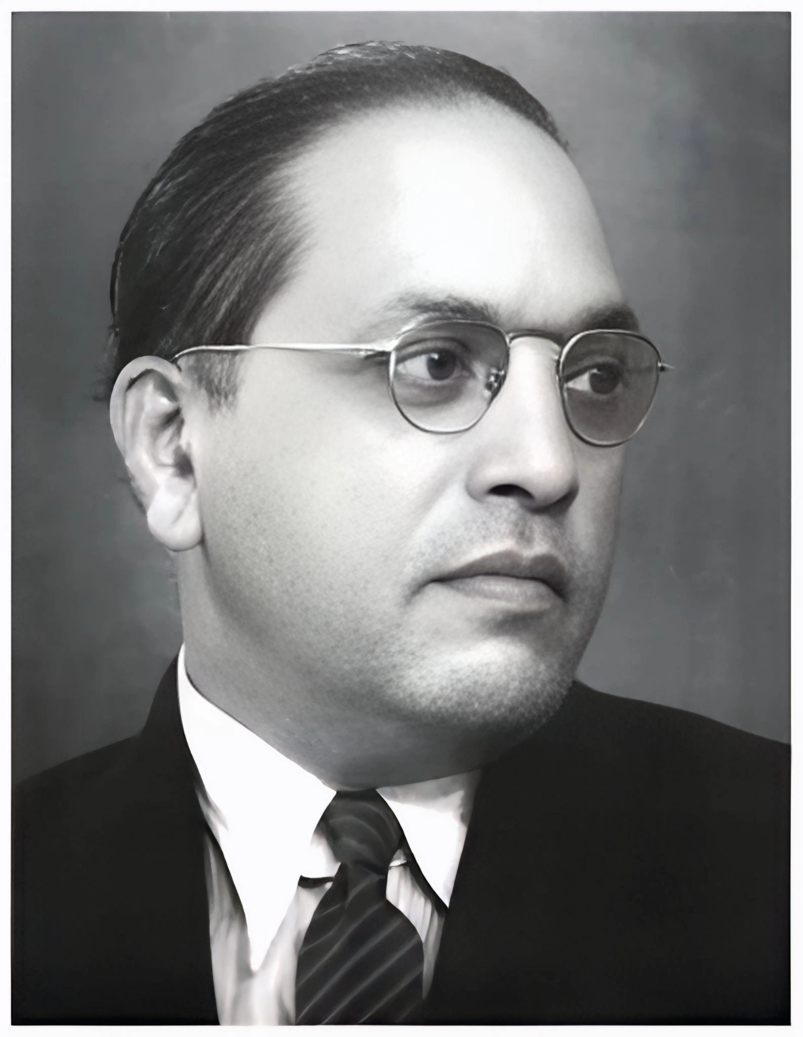 Black and white portrait of a man wearing glasses and a suit.