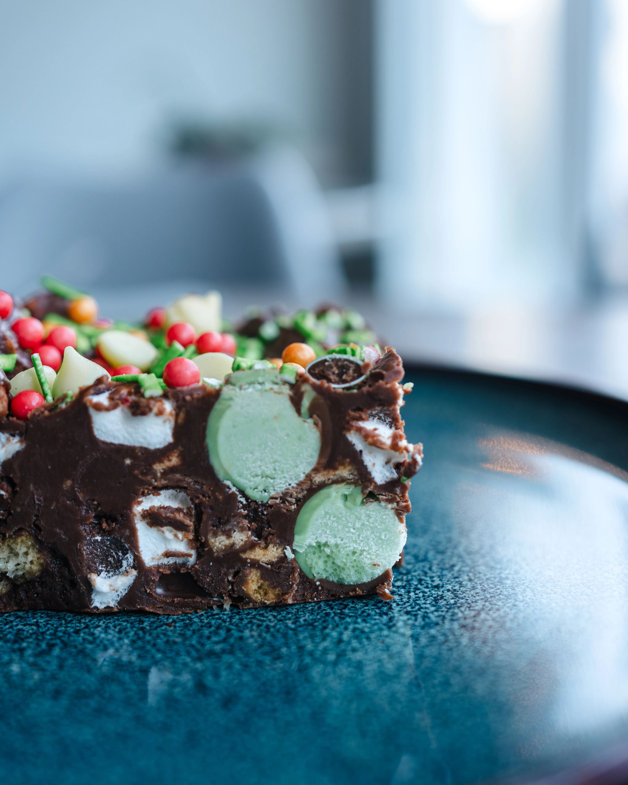 Close-up of a colorful rocky road dessert slice on a blue plate.