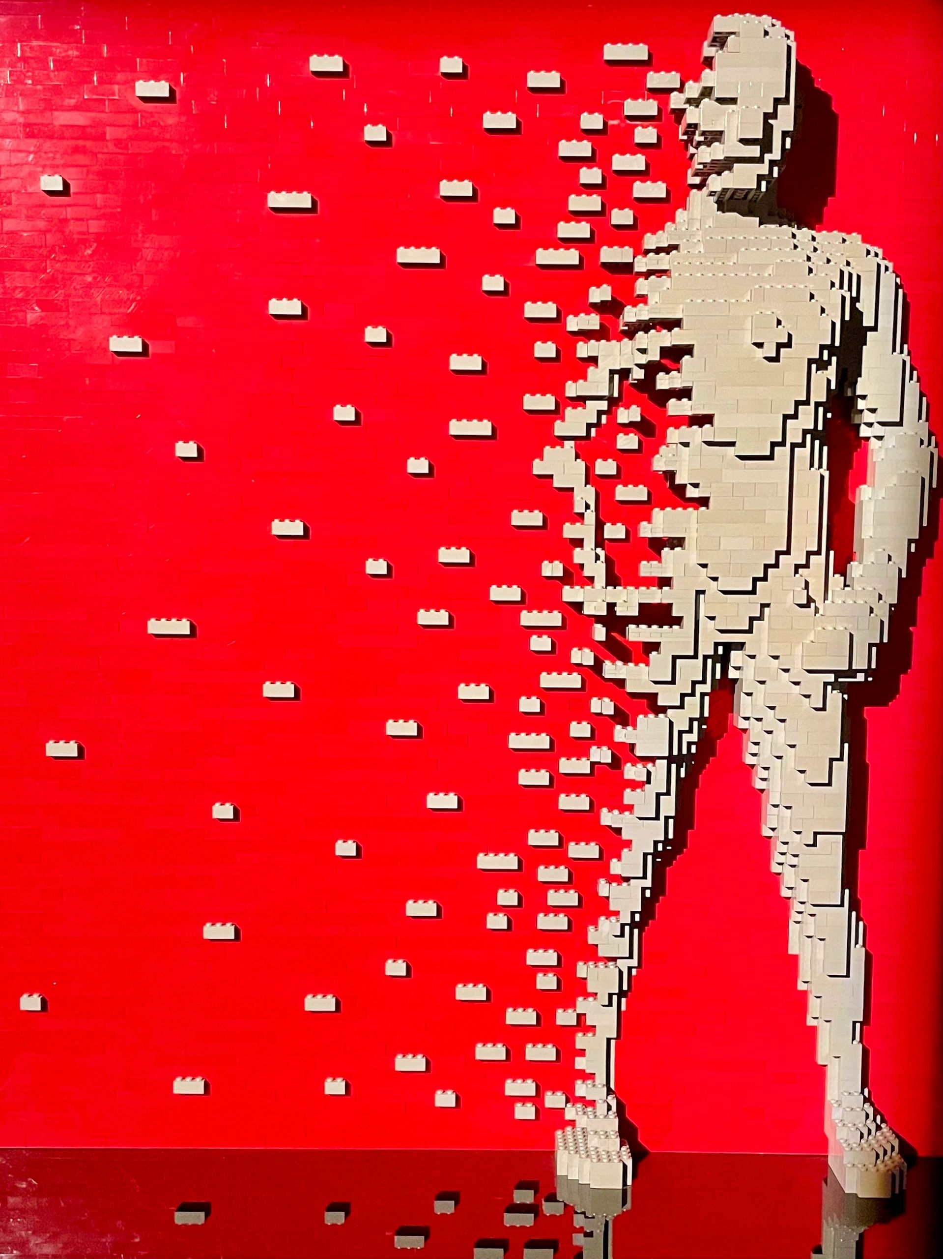 Lego bricks fly away from a human body.