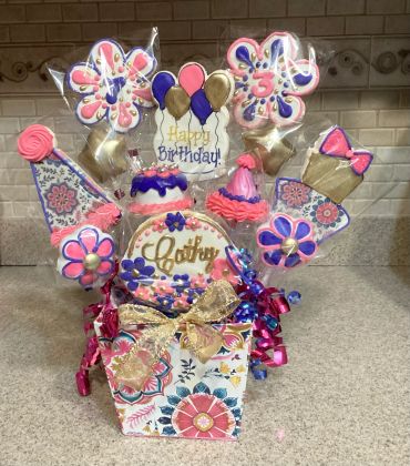 Colorful birthday cookie bouquet with pink, purple, and gold decorations.