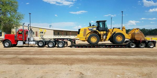 Lowboy hauling an oversized loader