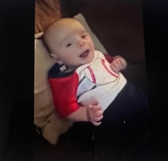 smiling baby laying on pillow