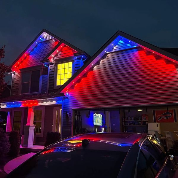 House decorated with red, white, and blue lights at night.